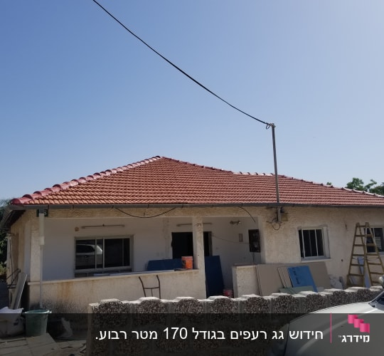 גג רעפים אדום עם אנטנה על גג בית